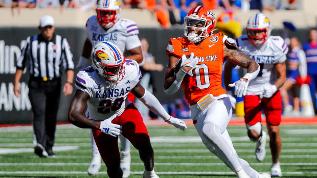 Oct 14, 2023; Stillwater, Oklahoma, USA; Oklahoma State's Ollie Gordon II (0) runs the ball against Kansas Jayhawks s JB Brown (28) in the first quarter at Boone Pickens Stadium. Mandatory Credit: Nathan J. Fish-USA TODAY Sports